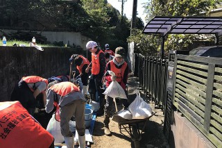 土嚢をねこ車（一輪車）に入れて運びます。